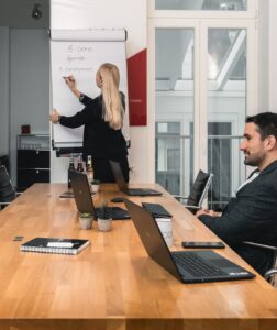 3-core im Interview mit Welt TV: Öffentliche Sicherheit unter Druck 5 Vier Personen befinden sich in einem Besprechungsraum. Drei sitzen an einem Holztisch mit Laptops, während einer an einem Flipchart steht und Notizen schreibt. Der Raum ist hell, hat große Fenster und ist minimalistisch eingerichtet.